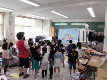 学級目標を見る子どもと先生
