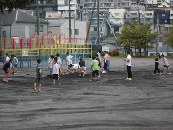 校庭に砂をまく６年生