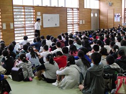 格技場で座って先生の話を聞く小学生