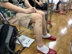 後半実技の様子。参加者のみなさんが自分の足のツボに台のついた「せんねん灸」を据えている写真。