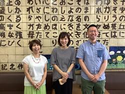 お招きした卒業生3名の写真。皆さん笑顔です。陶板に彫ってある横浜市立盲特別支援学校校歌の前にて。