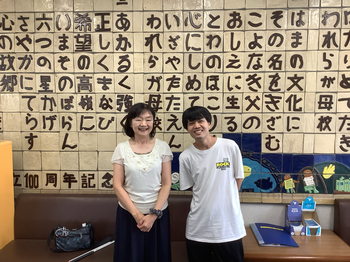 写真2は、校歌の歌詞が掘ってある壁の前で卒業生の中原先生と伊藤先生が並んで撮った写真です。 写真2は、校歌の歌詞が掘ってある壁の前で卒業生の中原先生と伊藤先生が並んで撮った写真です。